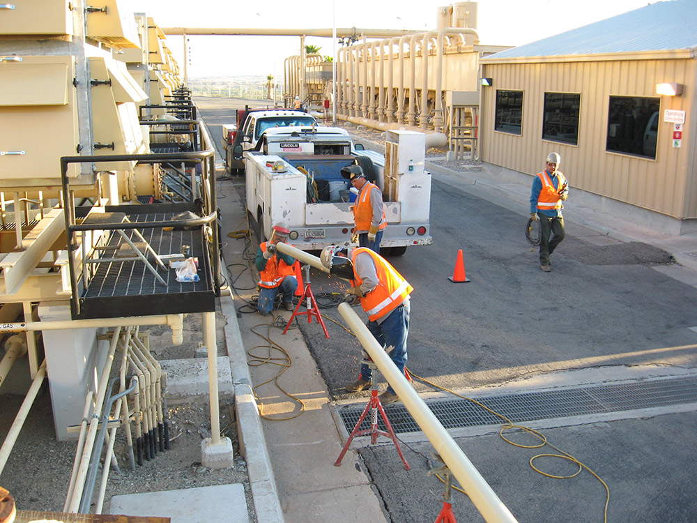 Alisto team of construction workers in hard hats and safety vests working on a building site