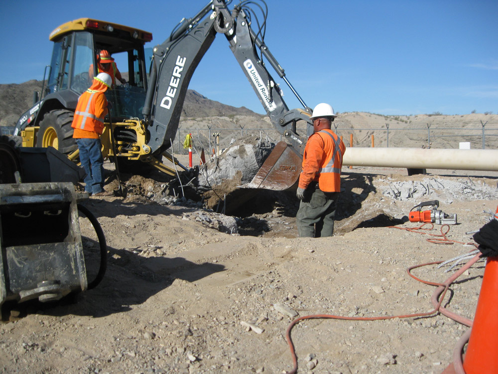 Alisto team members in orange shirts and hard hats working on a construction site