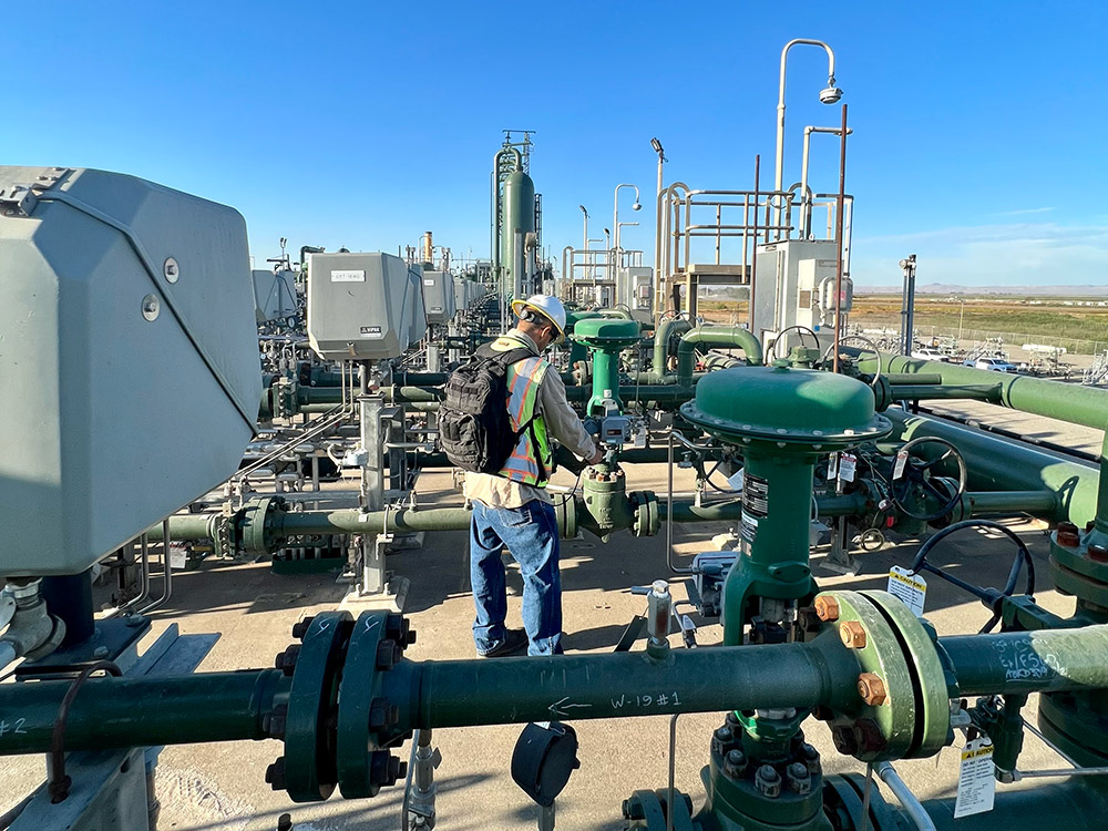 Alisto team member standing in front of a large pipe system checking for leaks